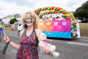 Woman wearing a multicoloured dress stood in front of a colourful display