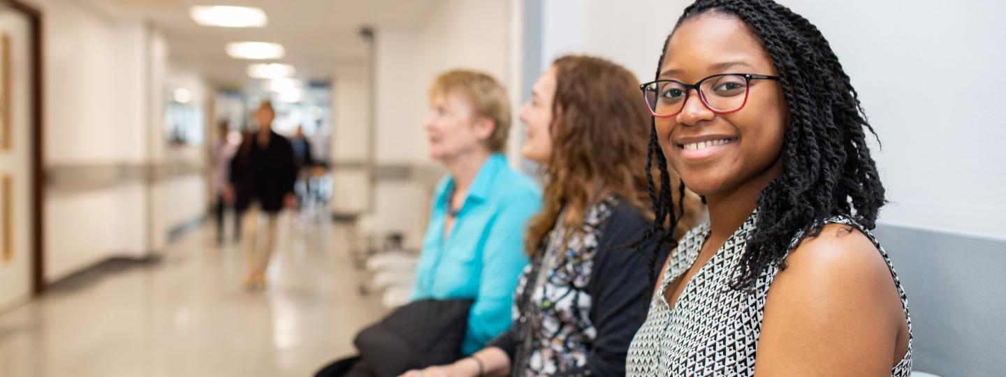 Three women sat waiting in a hospital corridor